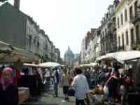 Several blocks lined on both sides with temporary market stalls and packed with people